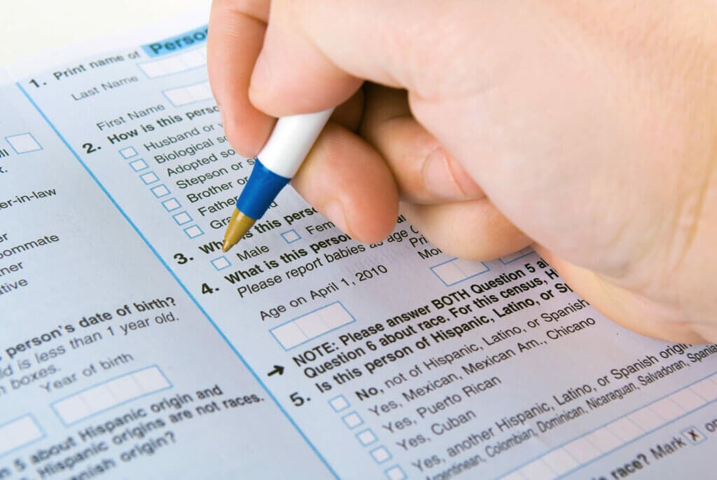 a person filling out a form with a pen|