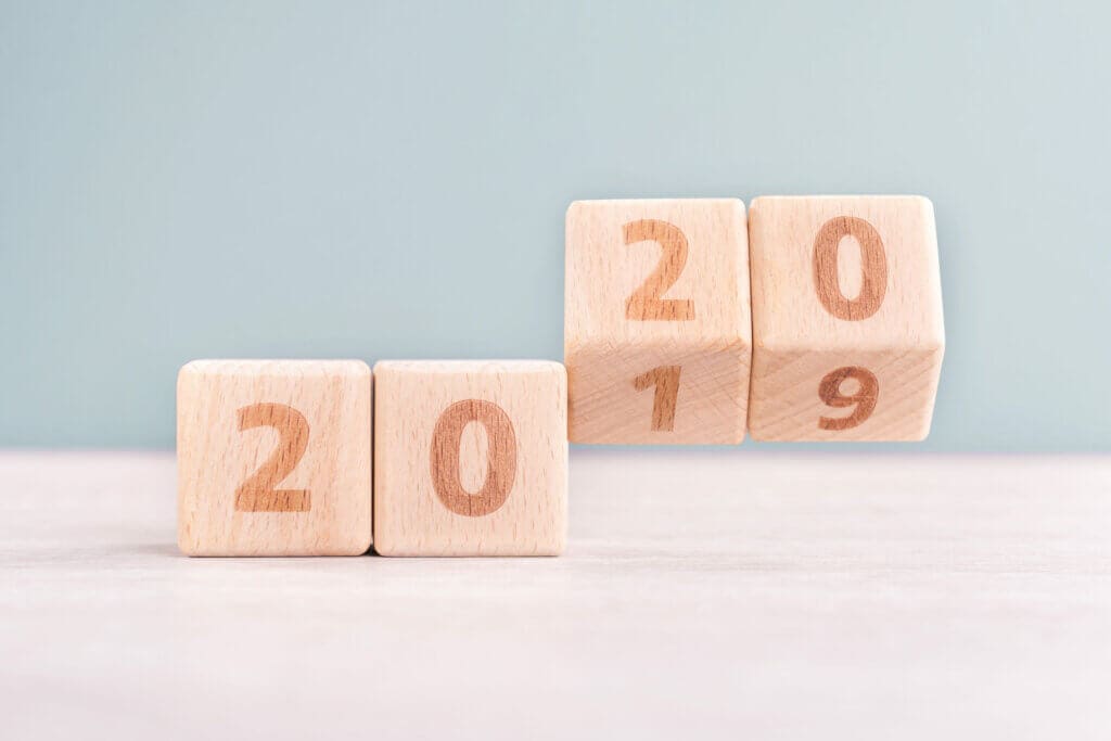 Abstract 2020 & 2019 New year countdown design concept - wood blocks cubes on wooden table and low saturation green background